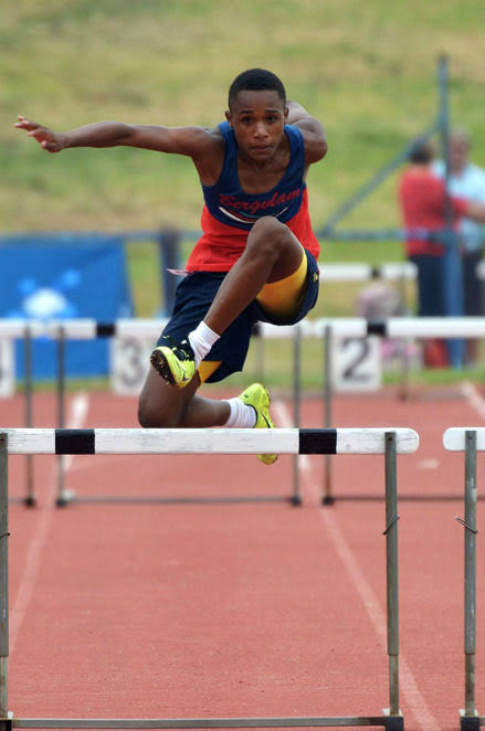 Young athlete clearing a hurdle