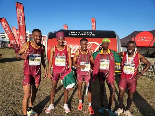 Squad of five athletes in maroon vests after a cross country race