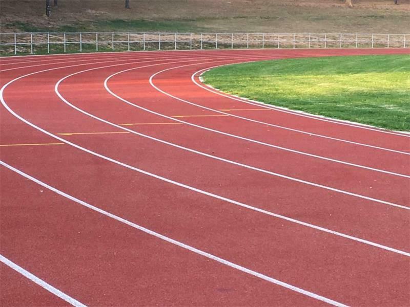 Curve of a red synthetic athletics track with lane markings